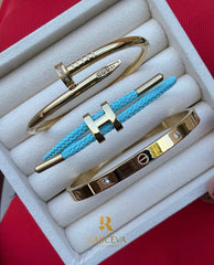 Ekser, Love, svetlo plava Lora narukvica u boji zlata.